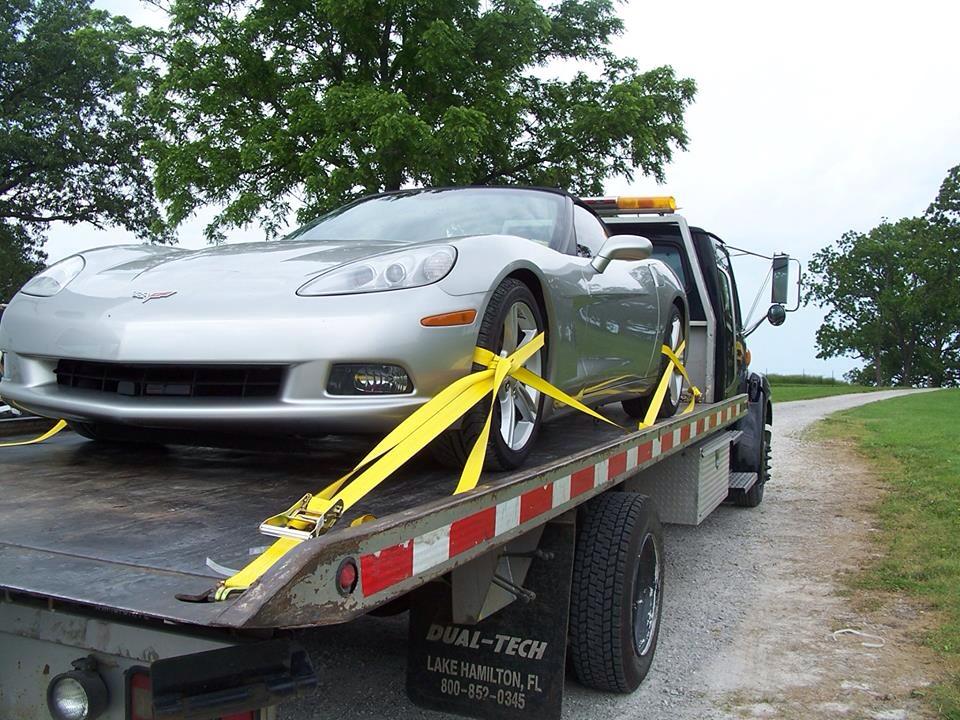 Flatbed tow truck hauling a car